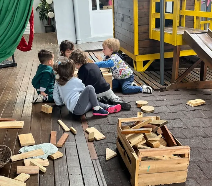 Crianças brincando com blocos de madeira no deque da escola
